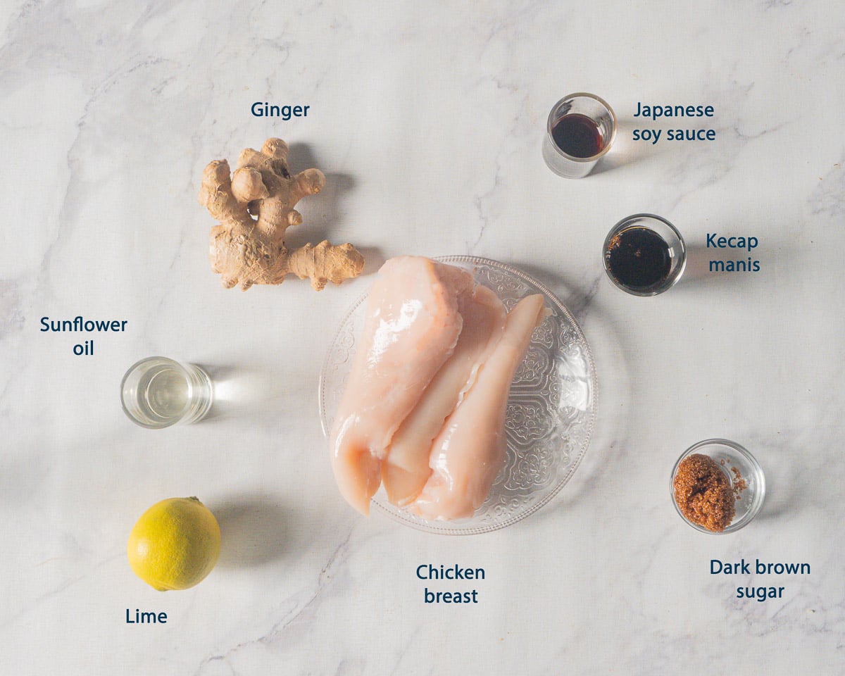 Overhead view of chicken breast, ginger, Japanese soy sauce, kecap manis, dark brown sugar, lime, and sunflower oil with English labels.